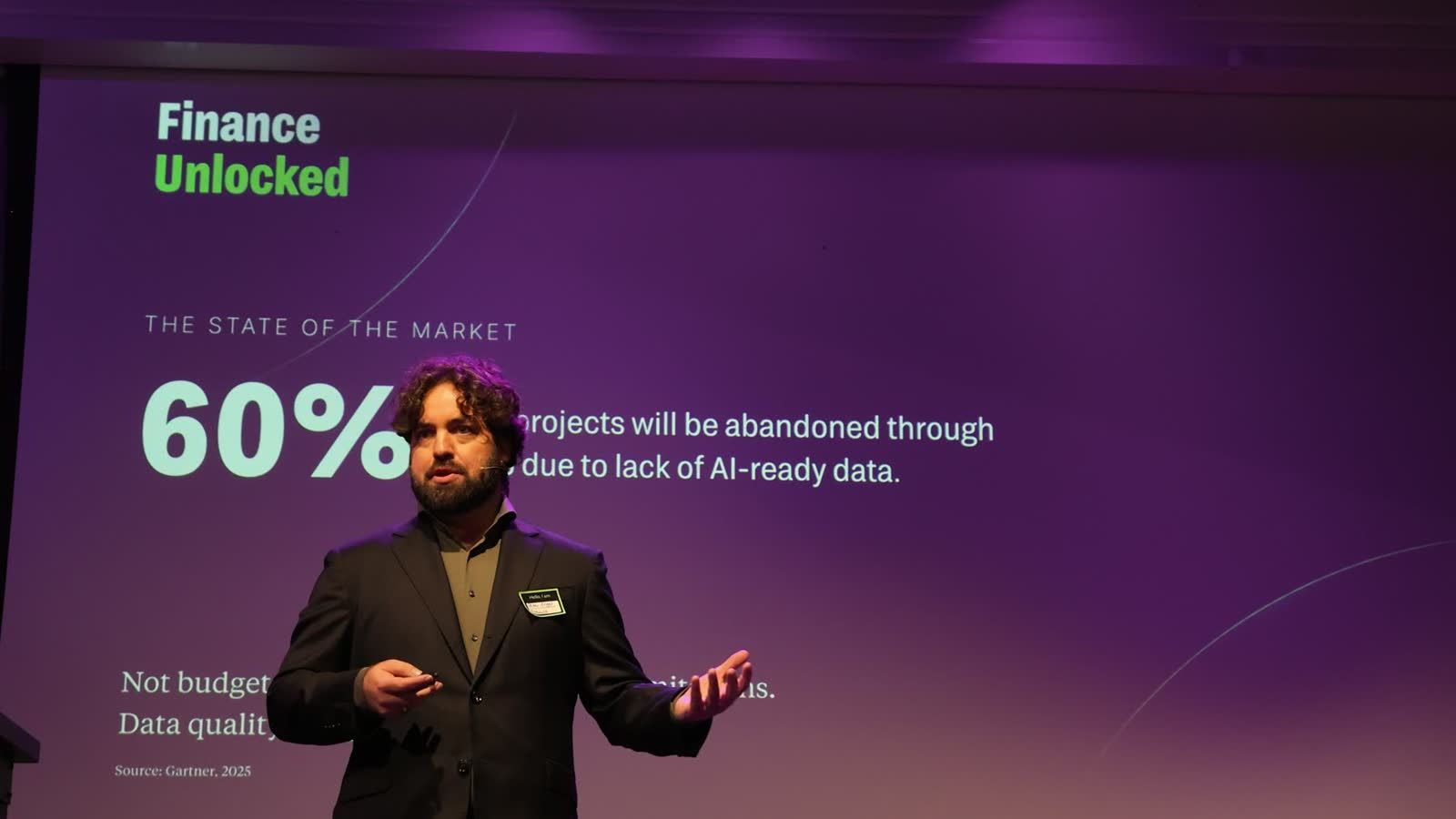 Peter Engel on stage at Finance Unlocked, with the 60% statistic on screen