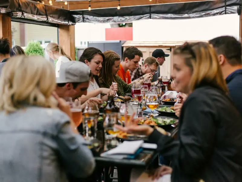 Gasten aan een lange tafel tijdens een lunch